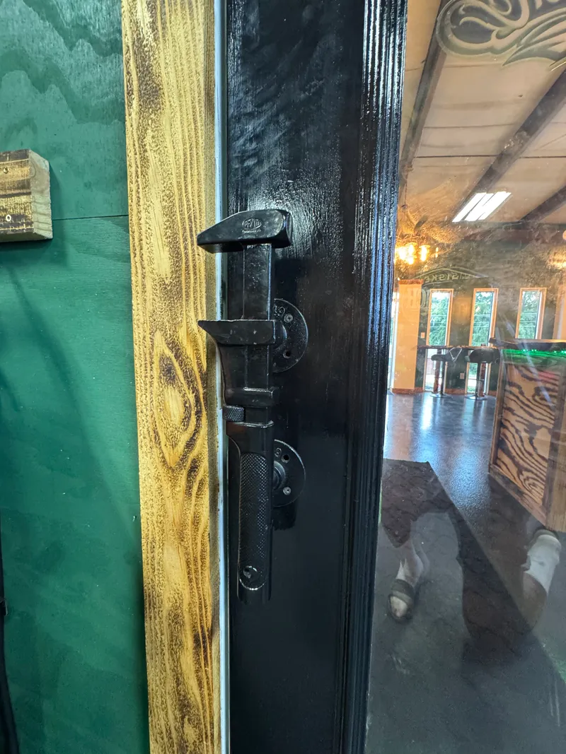 An antique pipe wrench mounted as the front door handle.